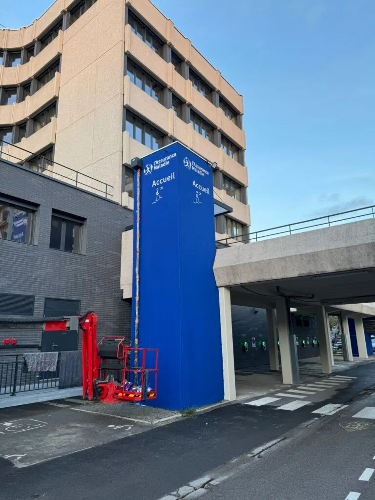 Enseigne totem lumineuse bleue installée en extérieur à Amiens