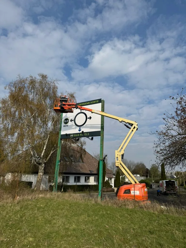 Installation d'une enseigne pylône à l'aide d'une nacelle élévatrice