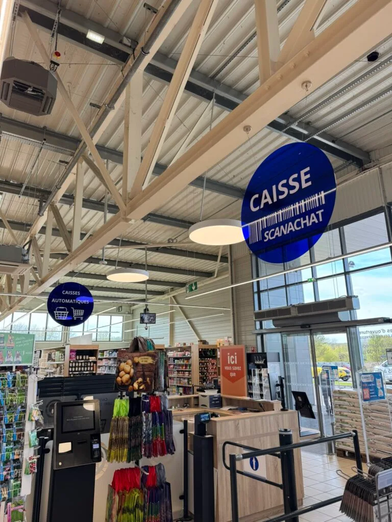 Enseigne lumineuse ronde 'Caisse' installée en intérieur de magasin